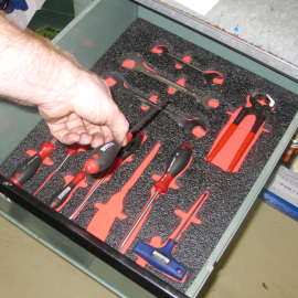 Hand nimmt Werkzeug aus Schublade