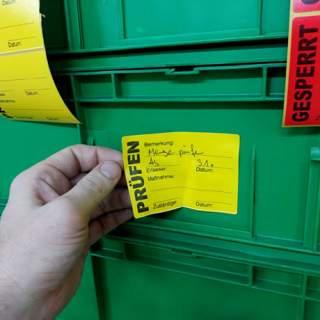 QS-Aufkleber für die Qualitätskontrolle auf grüner Box